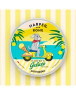 Envase redondo amarillo de helado para perros Harper and Bone sabor piña con ilustración de perro en scooter.